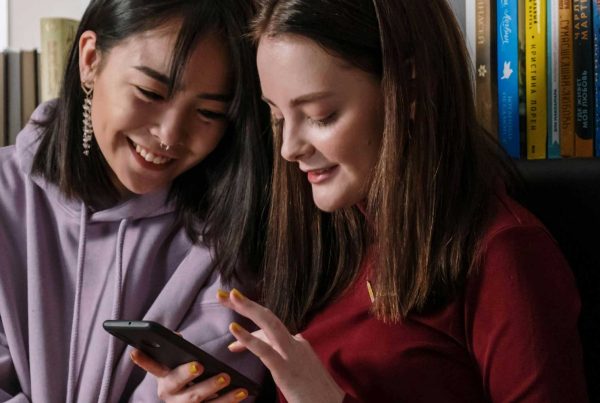 two gen z users looking at a mobile device